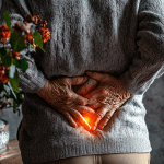An elderly lady holding her lower back in pain, indicating she needs stem cell treatment for her lower back