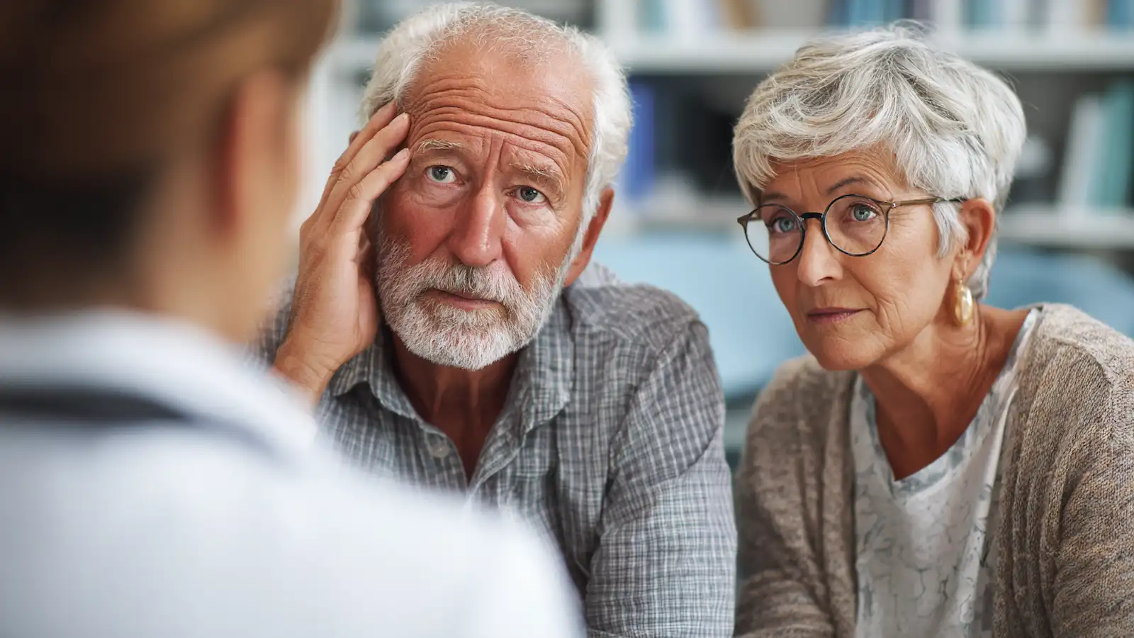 Concerned older couple listening to a doctor discuss Parkinson’s stem cell treatment options