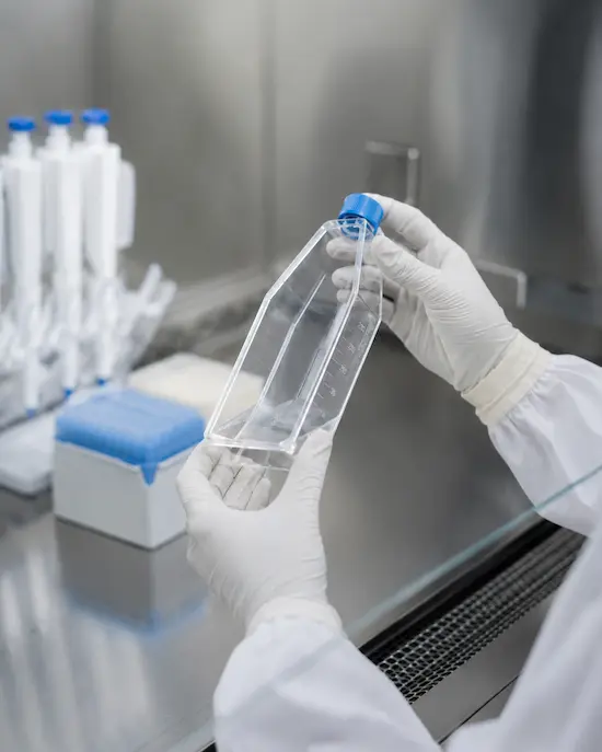 Researcher handling cell culture flask